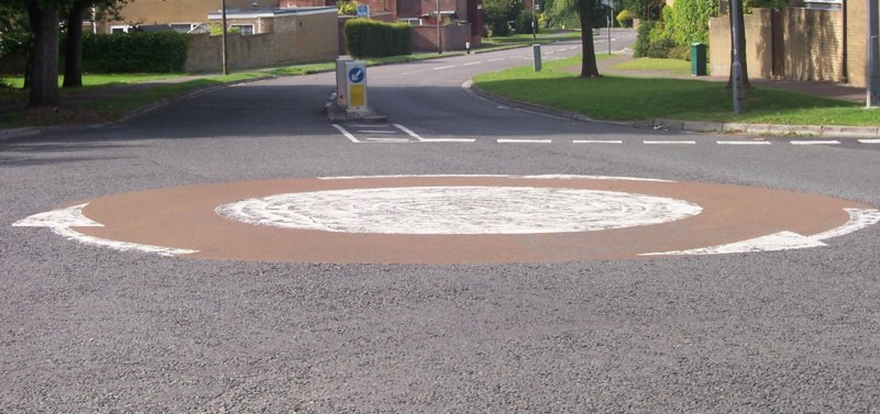 να τυπικό βρετανικό mini-roundabout σε αστικό δρόμο με διαγραμμίσεις.